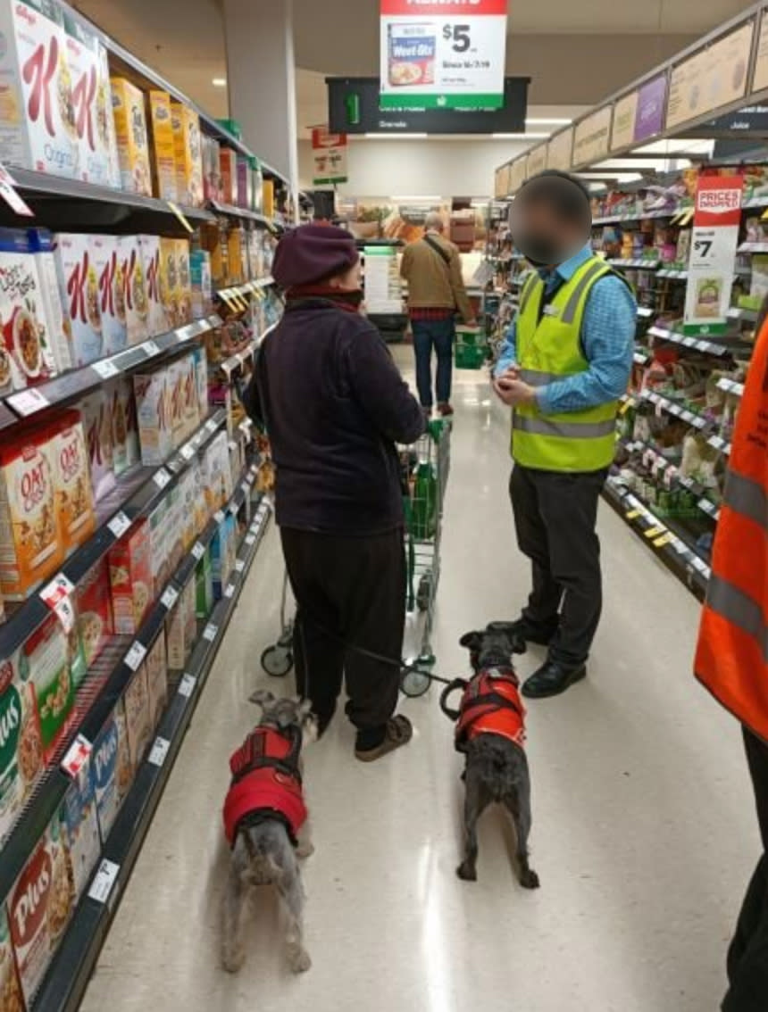 A Melbourne woman is pictured being spoken to by a Woolworths store manager on Saturday.