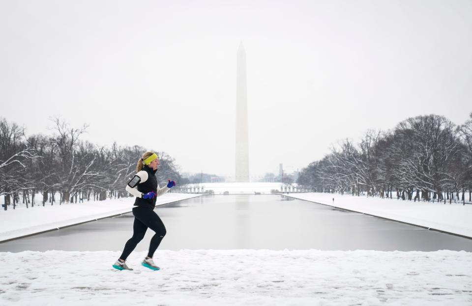 Runners brave the elements Jan. 16, 2024, near the Lincoln Memorial after snow fell on the nation's capital. The DC area got 2 to 5 inches of snow, snapping its snowless streak.