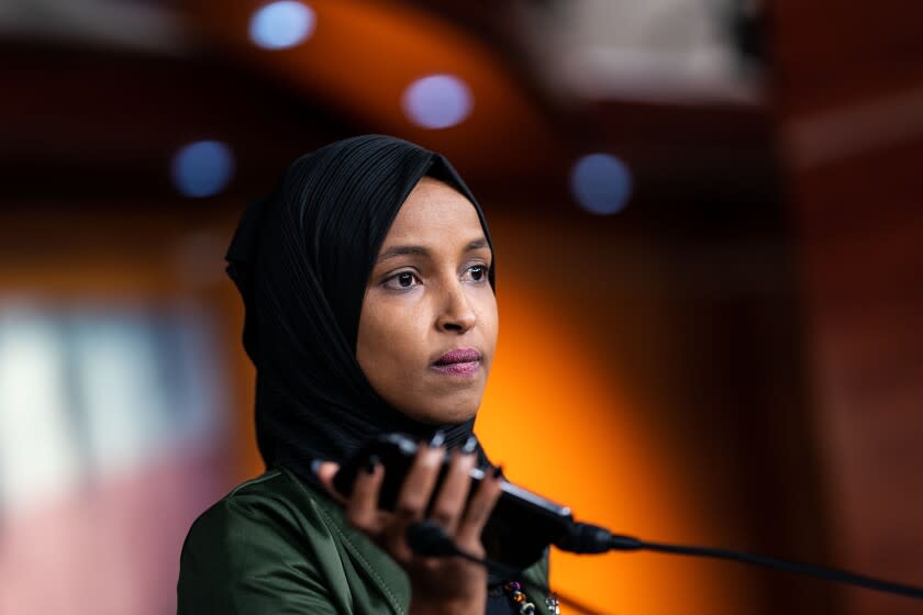 WASHINGTON, DC - NOVEMBER 30: Rep. Ilhan Omar (D-MN) plays a voicemail she received for reporters during a news conference with fellow Reps. Carson, Bowman and Talib addressing anti-Muslim comments made by Rep. Lauren Boebert (R-CO) on Capitol Hill on Tuesday, Nov. 30, 2021 in Washington, DC. (Kent Nishimura / Los Angeles Times)