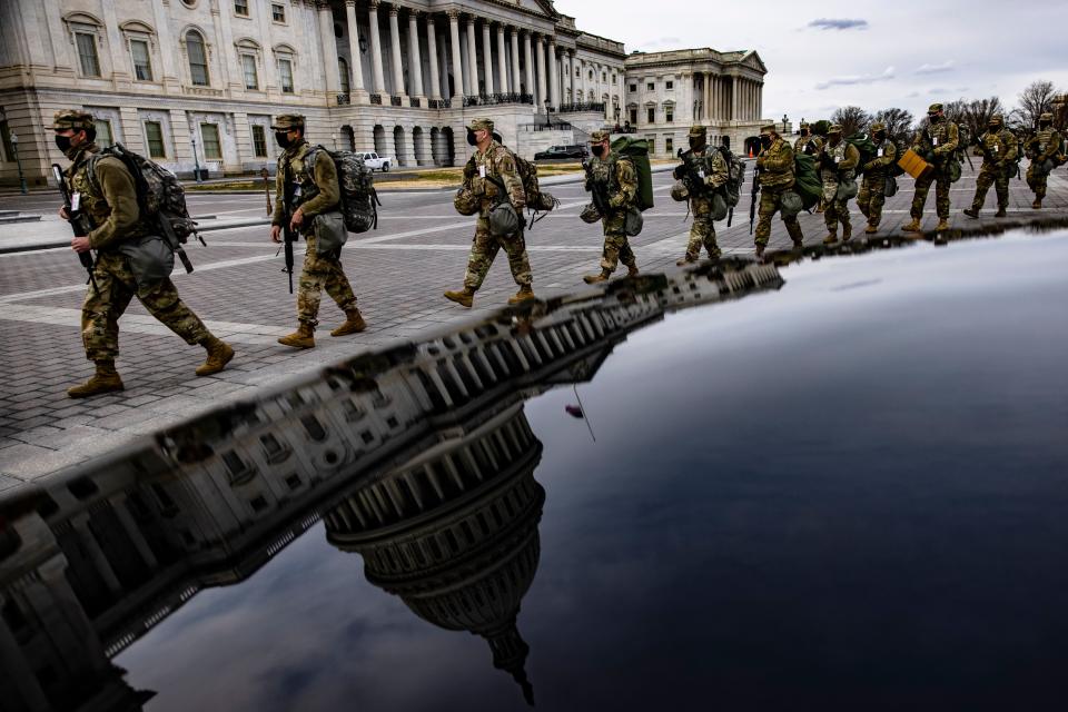 Virginia National Guard troops march across the east front of the U.S. Capitol on their way to their guard posts on Jan. 16 in Washington, DC. After the Jan. 6 riots at the U.S. Capitol, the FBI has warned of additional threats in the nation's capital and in all 50 states. (Samuel Corum via Getty Images)