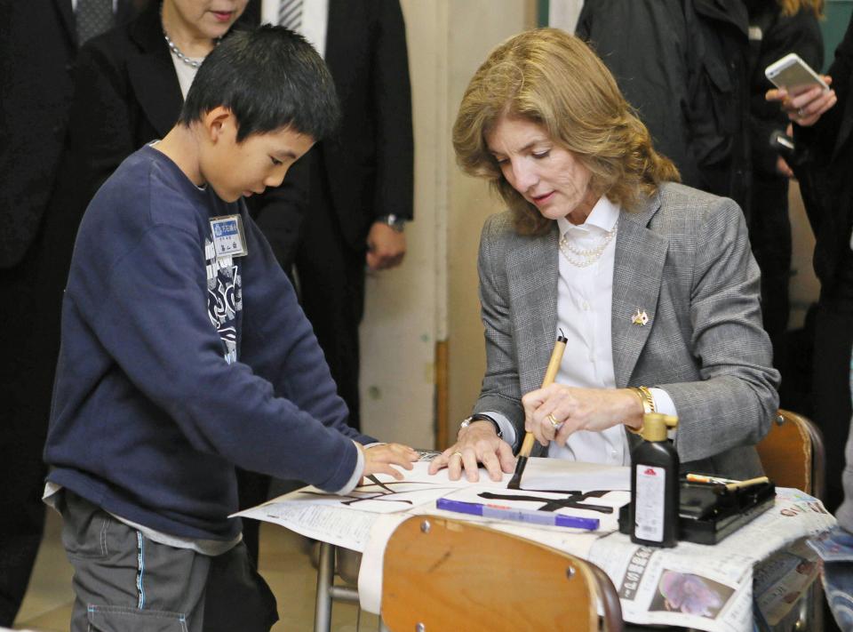 Kennedy uses a brush to write a Japanese word or character meaning "Friends" at Mangokuura Elementary School in Ishinomaki