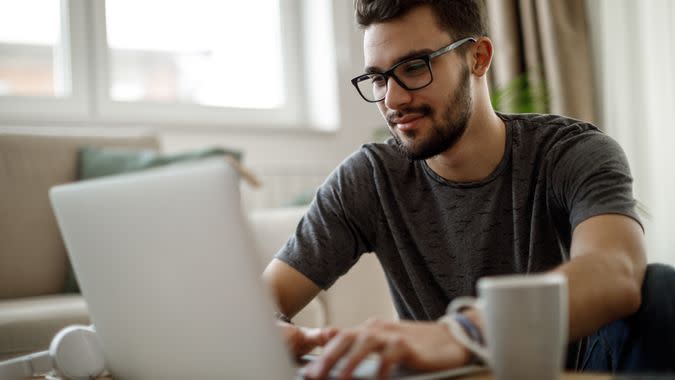 Teenage boy using laptop at home.