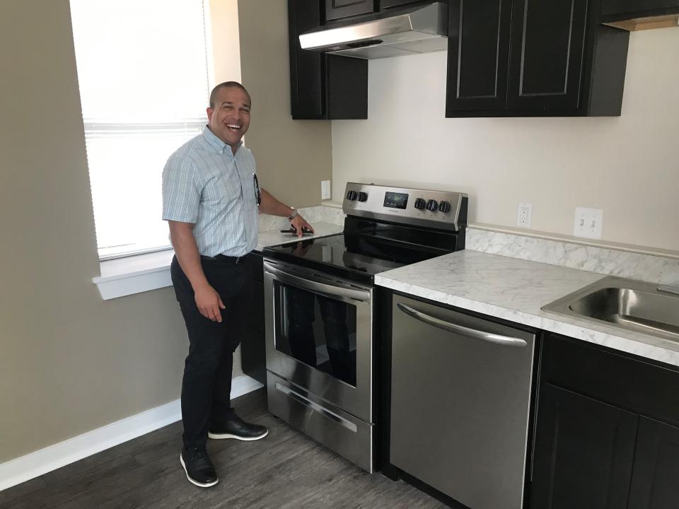 Wynton Fox, asset manager for Columbia-Maryland-based Enterprise Community Growth Fund, shows off the kitchen in one of eight units at a renovated historic apartment building on Detroit's far-east side. Fox's organization lent $1.7 million to the project, which includes another apartment building soon to open with 15 units. (Photo: Bill Laitner)
