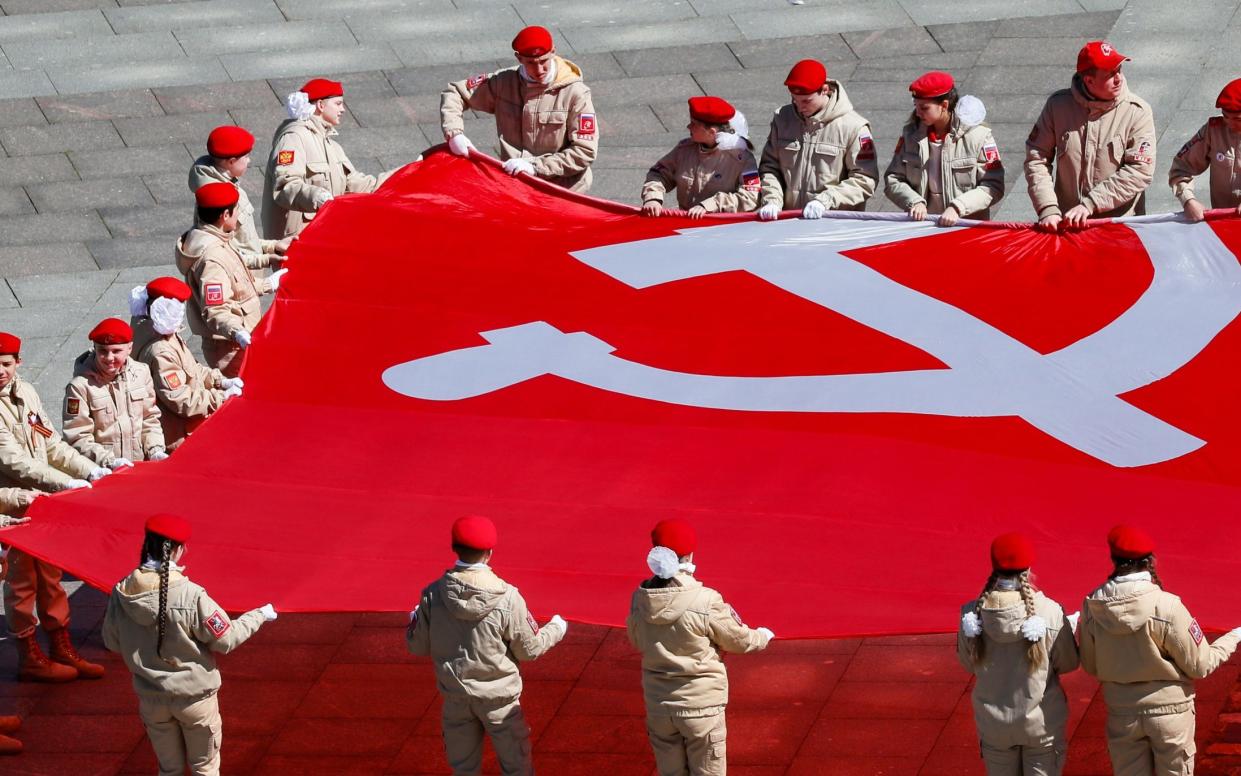 Russians hold a giant replica of the victory banner as they attend an event commemorating victory in WWII