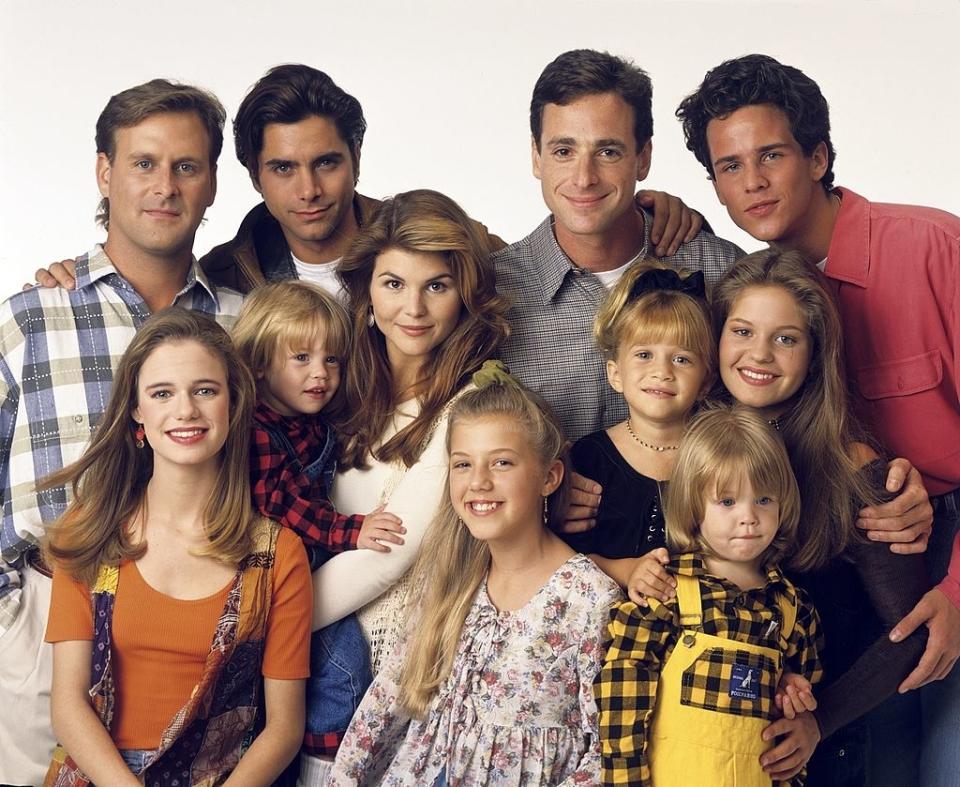 Cast of 'Full House' posing together, smiling in casual attire