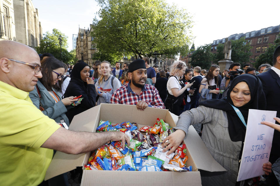 A man gives out food during a vigil in Albert Square, Manchester, after a 23-year-old man was arrested in connection with the Manchester concert bomb attack.