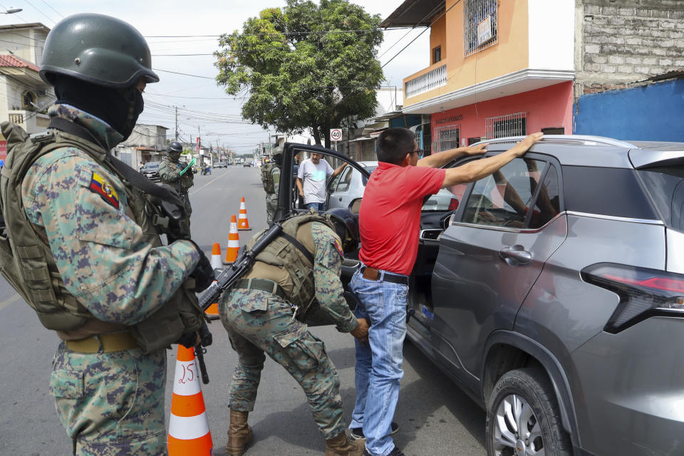 FILE - A soldier pats down a driver at a road block in Guayaquil, Ecuador, Aug. 10, 2023. President Guillermo Lasso declared a state of emergency that involves additional military personnel deployed throughout the country a day after the assassination of presidential candidate Fernando Villavicencio at a campaign rally in Quito. (AP Photo/Cesar Munoz)
