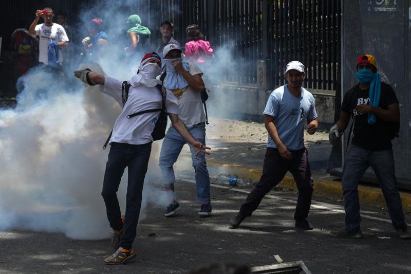 <p>Un manifestante opositor se enfrenta a integrantes de la Policía Nacional Bolivariana (PNB) durante una manifestación hoy, martes 4 de abril de 2017, que intentaba marchar hacia el Parlamento en apoyo a la destitución de los magistrados del Supremo, en Caracas (Venezuela). La Guardia Nacional Bolivariana de Venezuela (GNB, policía militar) disolvió hoy con gases lacrimógenos y perdigones de goma una manifestación de decenas de opositores que intentaban marchar hacia el Parlamento en apoyo a la destitución de los magistrados del Supremo, según constató Efe. EFE/CRISTIAN HERNÁNDEZ </p>
