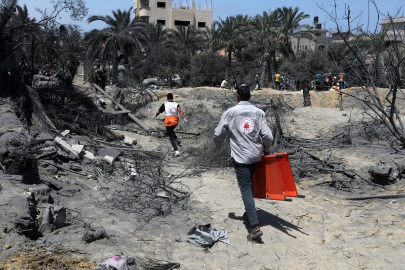 Emergency workers rush to attend to victims after an Israeli air strike on the Al-Mawasi camp for the displaced Palestinians. Abed Rahim Khatib/dpa