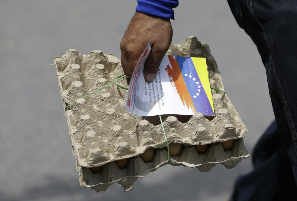 A Venezuelan man carrying a pack of eggs also clutches a flyer, given to him by Venezuelan politicians in exile, inviting people to come out to the streets on Feb. 23 to support a planned aid delivery to Venezuela, in La Parada, on the border with Venezuela, Colombia, Sunday, Feb. 17, 2019. As part of U.S. humanitarian aid to Venezuela, Sen. Marco Rubio, R-Fla, is visiting the area where the medical supplies, medicine and food aid is stored before it it expected to be taken across the border on Feb. 23. (AP Photo/Fernando Vergara)