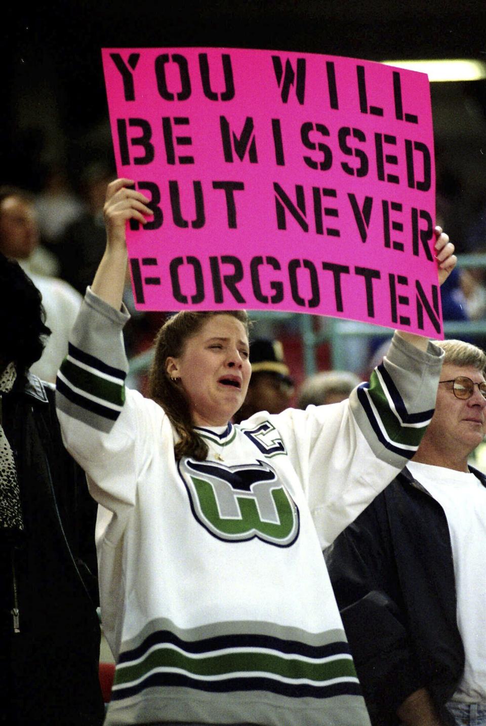 FILE - Hartford Whalers fan Jennifer Rice cries as she holds up a sign after the Hartford Whalers final NHL hockey game, Sunday, April 13, 1997, in Hartford, Conn., against the Tampa Bay Lightning. Connecticut Gov. Ned Lamont said Friday, May 19, 2023, he's planning to meet with NHL Commissioner Gary Bettman about the possibility of moving the Arizona Coyotes to Hartford. Connecticut has not had an NHL team since the Hartford Whalers left for North Carolina in 1997. (AP Photo/Steve Miller, File)