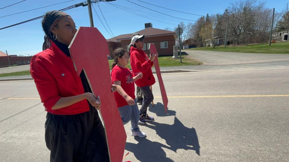 A group of five from Elsibogtog First Nation went through the community holding wooden cutouts of red dresses in honour of Red Dress Day.