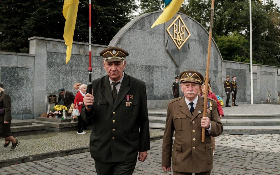 LVIV, UKRAINE â€“ OCTOBER 1: Veterans of the Ukrainian Insurgent Army (UPA) hold flags near the grave of the unknown soldier of the Ukrainian Insurgent Army (UPA) at Lychakiv Cemetery during the commemoration ceremony for Ukrainian defenders on October 1, 2023 in Lviv, Ukraine. Day of Defenders and Defendresses of Ukraine usually is marked on the day of the Intercession of the Theotokos. This year it is celebrated for the first time on October 1. (Photo by Les Kasyanov/Global Images Ukraine via Getty Images)