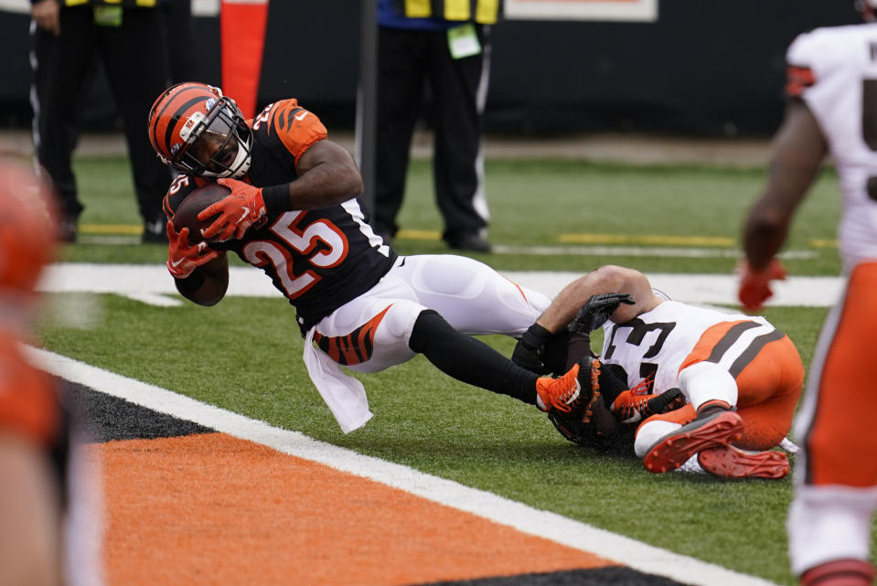 Cincinnati Bengals' Giovani Bernard (25) goes in for a touchdown while being tackled by Cleveland Browns' Andrew Sendejo (23) during the second half of an NFL football game, Sunday, Oct. 25, 2020, in Cincinnati. (AP Photo/Michael Conroy)