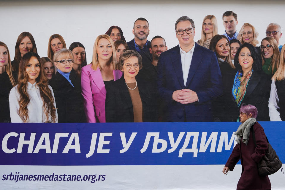 A woman walks past a pre-election billboard showing Serbian President Aleksandar Vucic with members of his ruling Serbian Progressive Party in Belgrade, Serbia, Wednesday, Dec. 6, 2023. When Serbia formally opened membership negotiations with the European Union, back in 2014, it was a moment of hope for pro-Western Serbs, eager to set their troubled country on an irreversible path to democratization. Those days are long gone. Now, they feel betrayed, both by the government and the EU. (AP Photo/Darko Vojinovic)