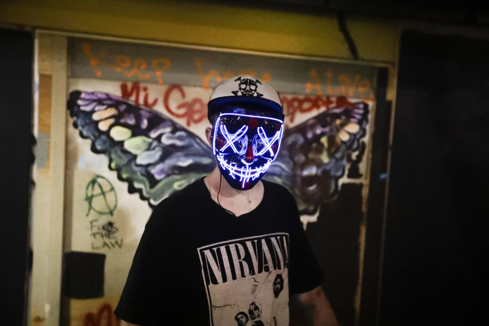 A protester wears a colorful mask during a Black Lives Matter protest at the Mark O. Hatfield United States Courthouse Thursday, July 30, 2020, in Portland, Ore. After days of clashes with federal police, the crowd outside of the federal courthouse remained peaceful Thursday night. (AP Photo/Marcio Jose Sanchez)