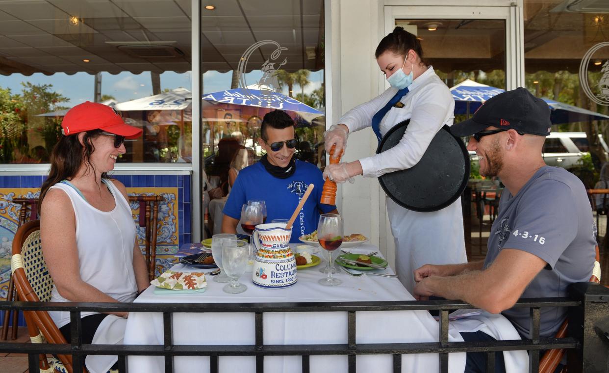 The Columbia Restaurant, on St. Armands Circle, is popular with locals and visitors. Here, newlyweds Kristy Clements, left, and Gary Roose, right, of Tampa, dine with Christopher Mouta, of Sarasota.