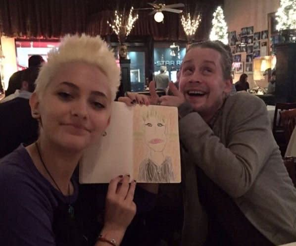 <p>In October, Paris shared a throwback of a dinner date she had with Mac, who knows what it’s like to <a rel="nofollow" href="https://www.yahoo.com/celebrity/macaulay-culkin-addresses-drug-rumors-222400385.html" data-ylk="slk:make rumors for just living;elm:context_link;itc:0;sec:content-canvas;outcm:mb_qualified_link;_E:mb_qualified_link;ct:story;" class="link  yahoo-link">make rumors for just living</a>. “Throwback to when the best godfather ever drew me,” she wrote alongside the pic, in which she’s holding up a portrait of herself as Culkin gives it two thumbs up. They’re both true characters — and it’s good they have each other. (Photo: Paris Jackson via Twitter) </p>