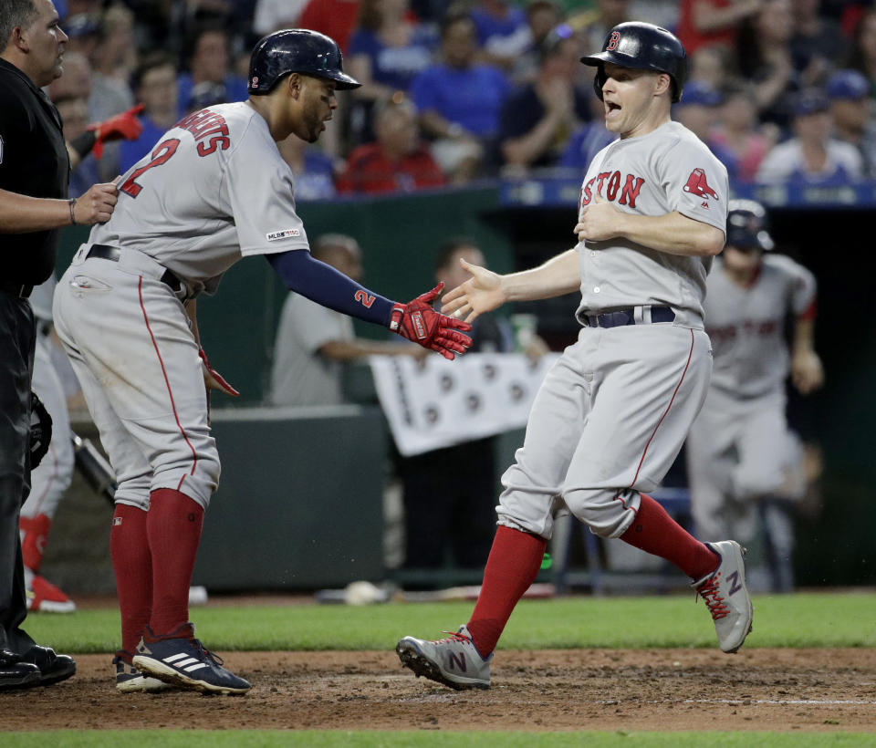 Boston Red Sox's Xander Bogaerts, left, and Brock Holt celebrate after scoring on a three-run double by Jackie Bradley Jr. during the fifth inning of a baseball game against the Kansas City Royals on Wednesday, June 5, 2019, in Kansas City, Mo. (AP Photo/Charlie Riedel)