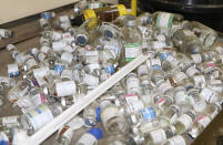 Empty vaccine bottles lie on a tray inside a small clinic in Gampela village on the outskirts of Burkina Faso's capital, Ouagadougou, Saturday Oct. 10, 2020. The public health clinic responsible for serving approximately 11,000 people, did not have a working fridge for almost a year. The vaccine cold chain hurdle is just the latest disparity of the pandemic weighted against the poor, who more often live and work in crowded conditions that allow the virus to spread, have little access to medical oxygen vital to COVID-19 treatment, and whose health systems lack labs, supplies or technicians to carry out large-scale testing. (AP Photo/Sam Mednick)