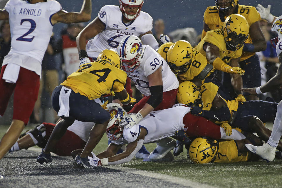 Kansas running back Devin Neal (4) scores a touchdown while defended by West Virginia safety Marcis Floyd (24) during the second half of an NCAA college football game in Morgantown, W.Va., Saturday, Sept. 10, 2022. (AP Photo/Kathleen Batten)