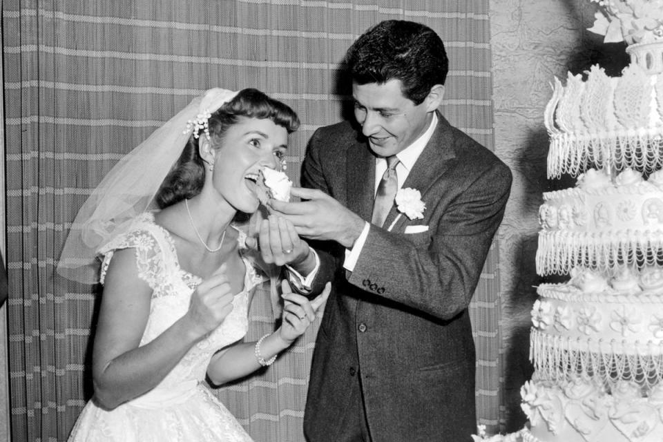 Singer Eddie Fisher feeds a piece of wedding cake to his bride, actress Debbie Reynolds following their marriage at Grossinger's in Liberty, NY, on 26 September 1955 (AP1955)