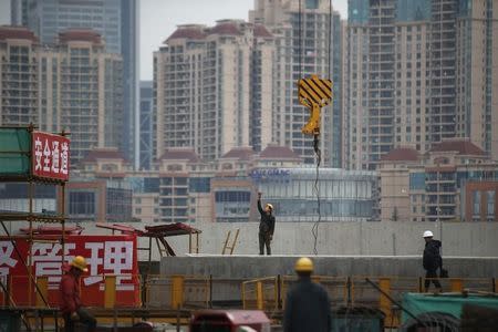 Labourers work at a construction site for a new building in Shanghai, March 5, 2015. REUTERS/Aly Song