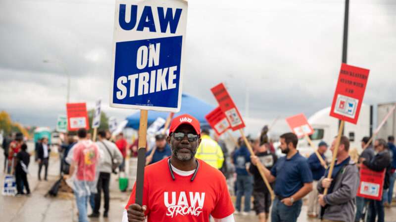 A member of the United Auto Workers (UAW) union holds a sign saying "UAW ON STRIKE" outside a Ford plant in Wayne, Michigan.