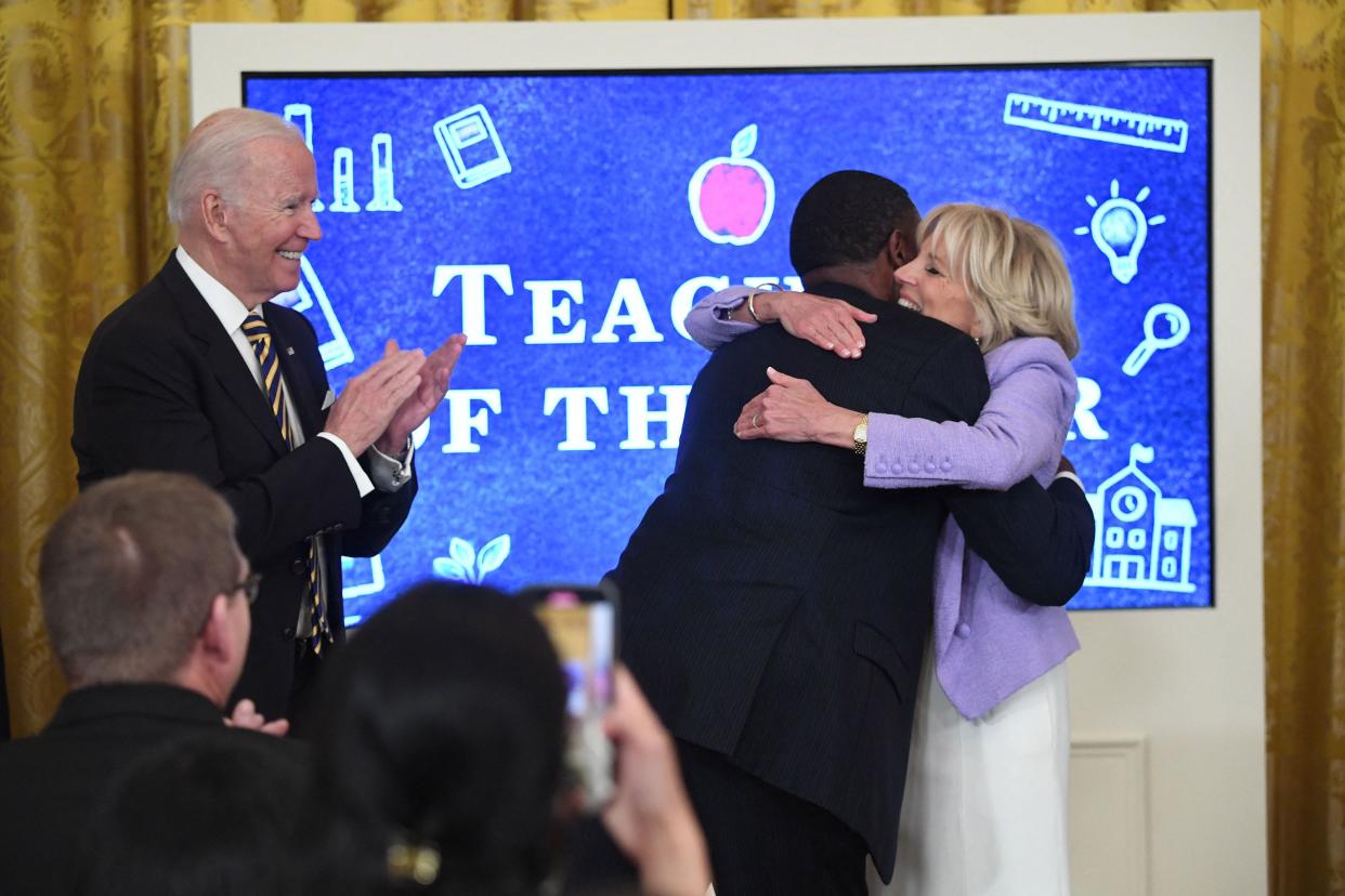 U.S. President Joe Biden watches as First Lady Jill Biden hugs Kurt Russell, the 2022 National Teacher of the Year, during a ceremony honoring the Council of Chief State School Officers 2022 National and State Teachers of the Year in the East Room of the White House in Washington, DC, April 27, 2022.