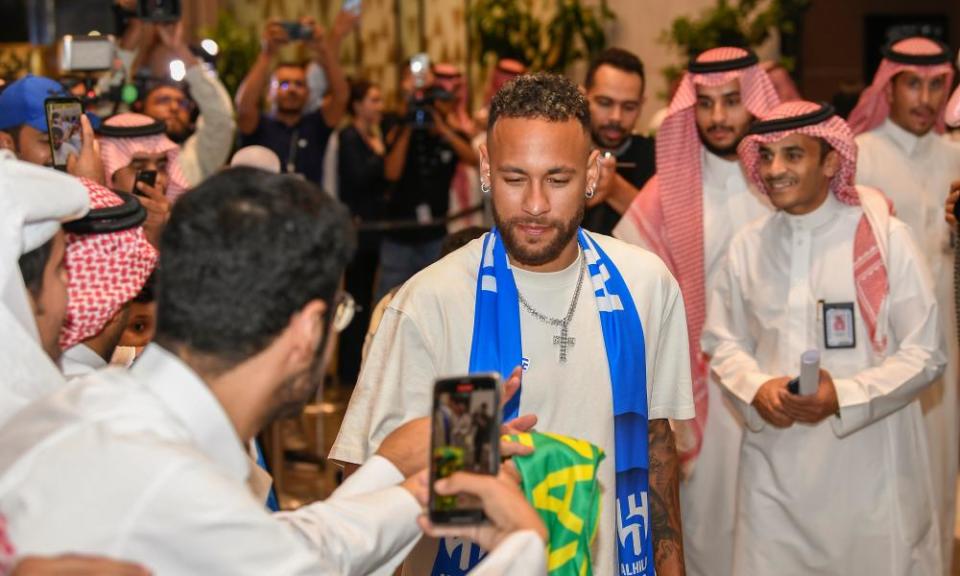 Neymar greets fans as he arrives at the airport in Riyadh, Saudi Arabia.