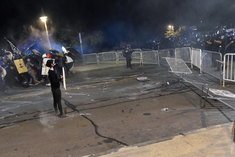 Demonstrators clash with police officers a block from the Public Safety Building in Rochester, N.Y., Friday, Sept. 4, 2020, after a rally and march protesting the death of Daniel Prude. Prude apparently stopped breathing as police in Rochester were restraining him in March 2020 and died when he was taken off life support a week later. (AP Photo/Adrian Kraus)