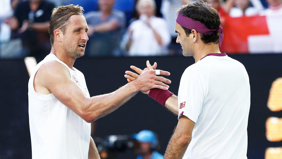 Roger Federer (picture right) and Tennys Sandgren (pictured left) embrace and shake hands.