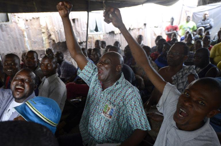 People react as partial results of the Nigerian presidential elections are released by the Independent National Electoral Commission indicating the main opposition APC presidential candidate is ahead, in Lagos on March 31, 2015