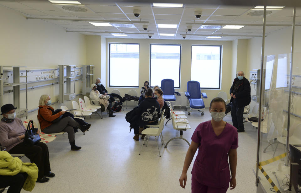 Polish teachers wait to be administered with their first shot of the AstraZeneca vaccine against the coronavirus in Krakow, Poland, Friday Feb. 12, 2021. As Poland began vaccinating teachers on Friday, many say they are unhappy that they are getting AstraZeneca vaccines against the coronavirus, rather than the Pfizer shots earmarked for health care workers and the elderly. Nearly a year into the pandemic, many Europeans and others globally are desperate to get vaccinated and return to normal life. But many don't want just any vaccine. (AP Photo/Czarek Sokolowski)