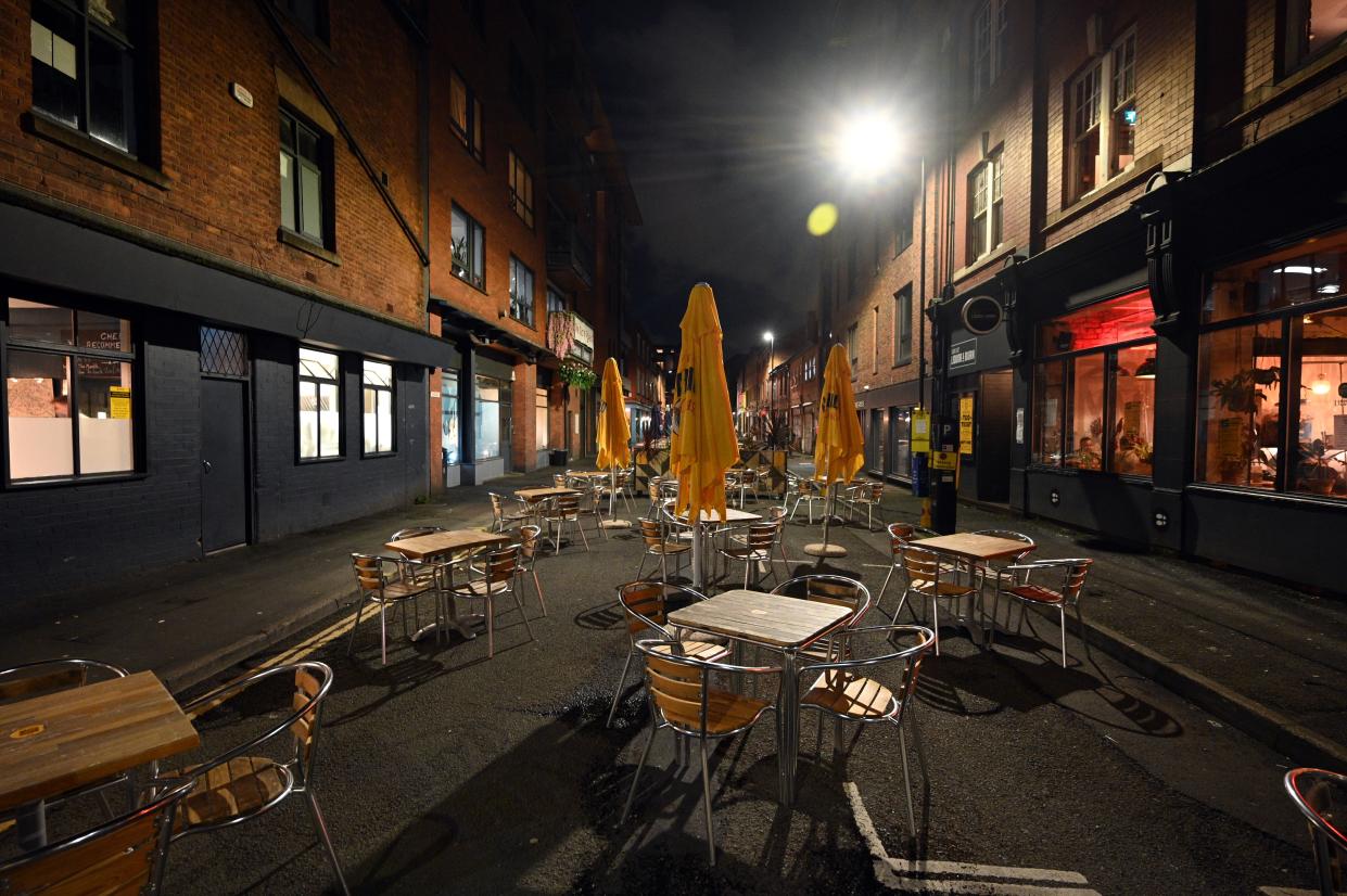 Empty tables and chairs at an outdoor eating area in Manchester