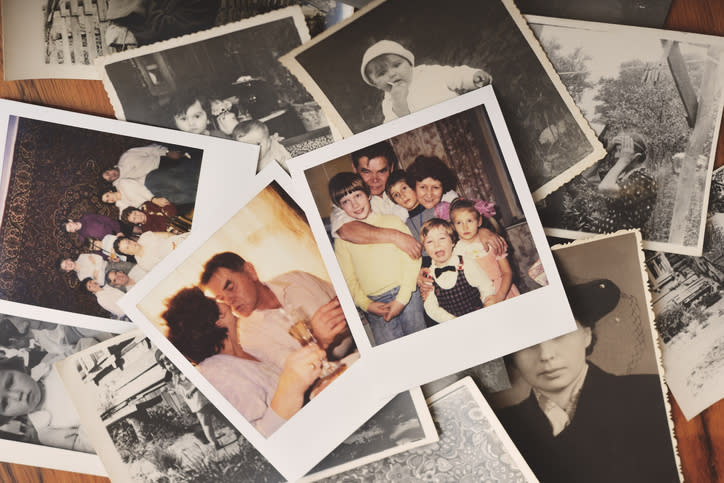 Various black and white family photographs and one color photo showing a family group with children in the center, surrounded by other vintage photos