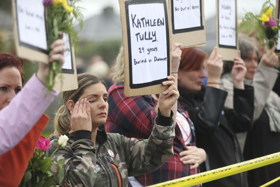 People hold up names of children as they gather to protest at the site of the former Tuam home for unmarried mothers in County Galway, during the visit to Ireland by Pope Francis, Sunday, Aug. 26, 2018. Survivors of one of Ireland's wretched mother and baby homes hold their own demonstration Sunday. The location is Tuam, site of a mass grave of hundreds of babies who died at a church-run home. (Niall Carson/PA via AP)