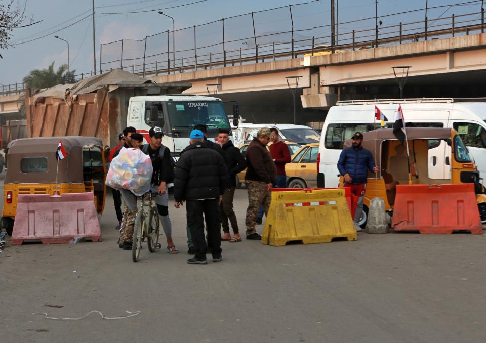 Members of Saraya Salam (Peace Brigades) militia search people heading to Tahrir Square where ongoing anti-government protests are taking place in Baghdad, Iraq, Sunday, Dec. 8, 2019. Iraqi security forces on Sunday have set up checkpoints manned alongside unarmed members of a militia group, Iraqi police officials said, to protect anti-government protesters in central Baghdad plazas, days after a deadly attack by unknown gunmen. The militia group are linked to influential Shiite cleric Muqtada al-Sadr, and have been present in Tahrir Square, the epicenter of Iraq's protest movement, where they have offered protection for hundreds of peaceful demonstrators. (AP Photo/Khalid Mohammed)