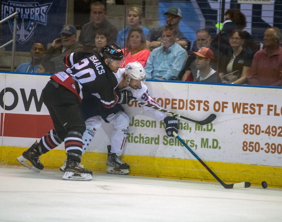 Thunderbolts' James Isaacs (20) and Ice Flyers' Henry McKinney (91) battle for the puck as the Ice Flyers take on the Evansville Thunderbolts at the Pensacola Bay Center Saturday, March 25, 2023.