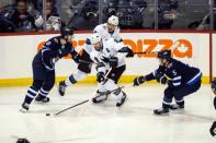 Feb 5, 2019; Winnipeg, Manitoba, CAN; San Jose Sharks forward Joe Pavelski (8) skates between Winnipeg Jets defenseman Jacob Trouba (8) and Winnipeg Jets defenseman Dmitry Kulikov (5) during the third period at Bell MTS Place. Mandatory Credit: Terrence Lee-USA TODAY Sports