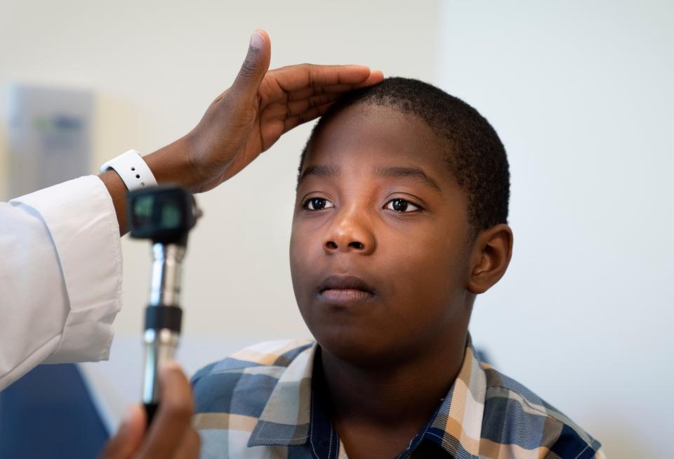 Dr. Joane Cadet examines Kendel Marius, 8, during a physcial exam at a back-to-school health fair for students. Free hearing and vision screenings, school physicals, vaccines and a backpack filled with school supplies were free at FoundCare in Palm Springs, Florida on August 6, 2022. 