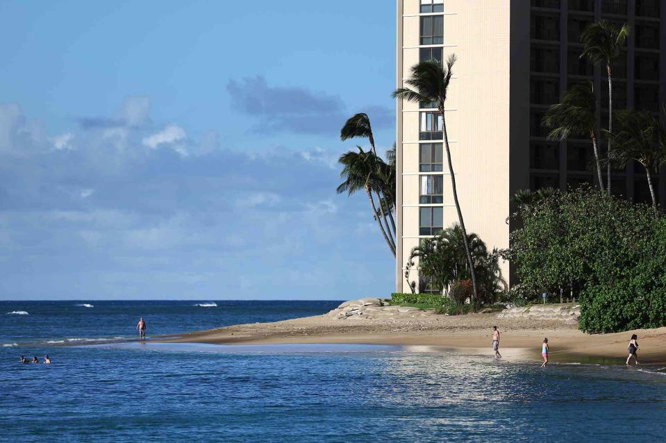 <p>Mario Tama/Getty Images</p> People gather on the beach near a condo rental resort on the first day of tourism resuming in parts of west Maui on October 08, 2023 near Lahaina, Hawaii. 