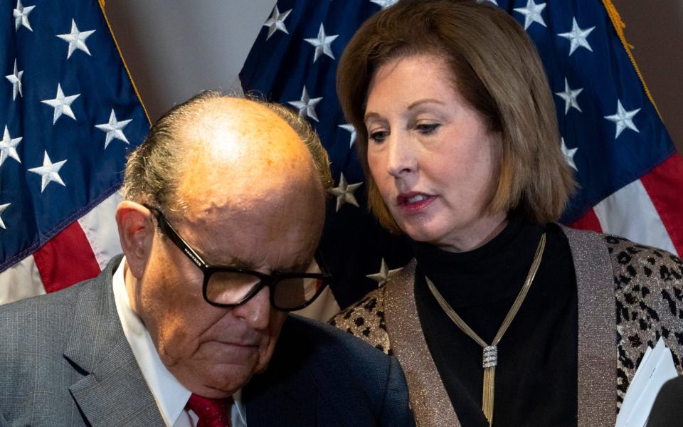 Rudy Giuliani listens to Sidney Powell during a news conference at the Republican National Committee headquarters - AP