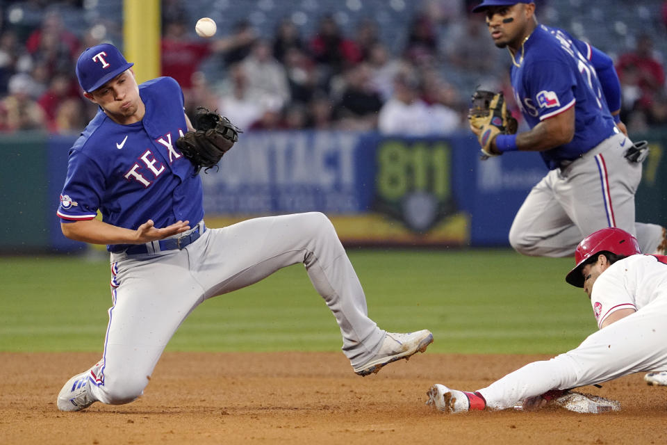 Texas Rangers shortstop Corey Seager, left, misses the throw from home as Los Angeles Angels' Tyler Wade steals second during the fourth inning of a baseball game Tuesday, May 24, 2022, in Anaheim, Calif. (AP Photo/Mark J. Terrill)