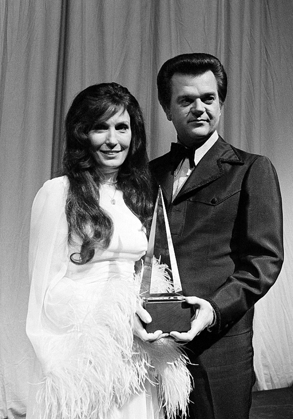 FILE - This 1975 file photo shows country music singers Loretta Lynn, left, and Conway Twitty with their trophy at the American Music Awards in Los Angeles. The duet won favorite duo group or chorus. The 47th annual awards, hosted by Carrie Underwood and Brad Paisley, airs Wednesday, Nov. 6, 2013. (AP Photo/File)