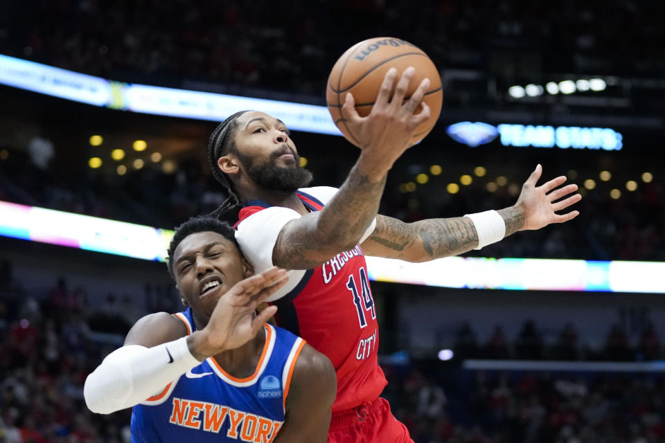New Orleans Pelicans forward Brandon Ingram (14) pulls in an offensive rebound over New York Knicks guard RJ Barrett in the first half of an NBA basketball game in New Orleans, Saturday, Oct. 28, 2023. (AP Photo/Gerald Herbert)
