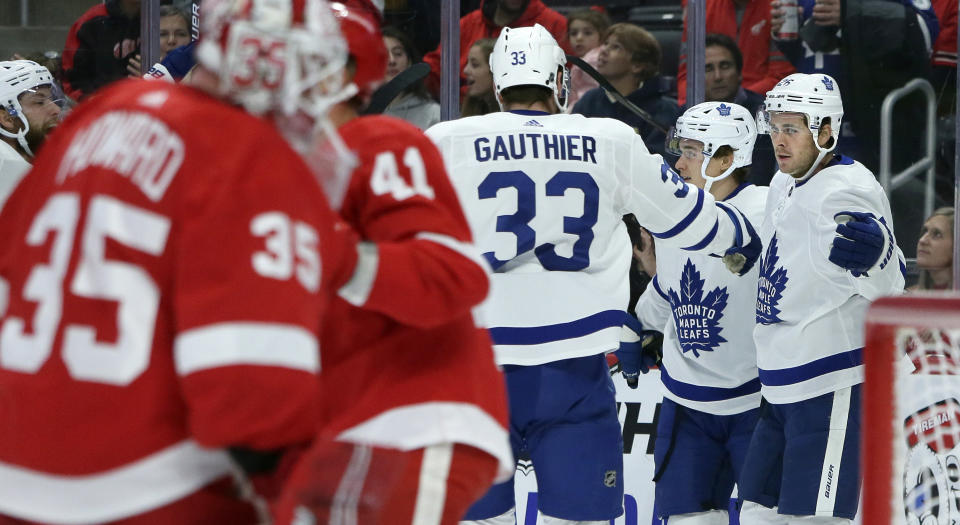 Toronto Maple Leafs center Nicholas Shore, right, celebrates with center Frederik Gauthier (33) and left wing Dmytro Timashov, center, of Ukraine, after scoring against the Detroit Red Wings during the first period of an NHL hockey game, Saturday, Oct. 12, 2019, in Detroit. (AP Photo/Duane Burleson)