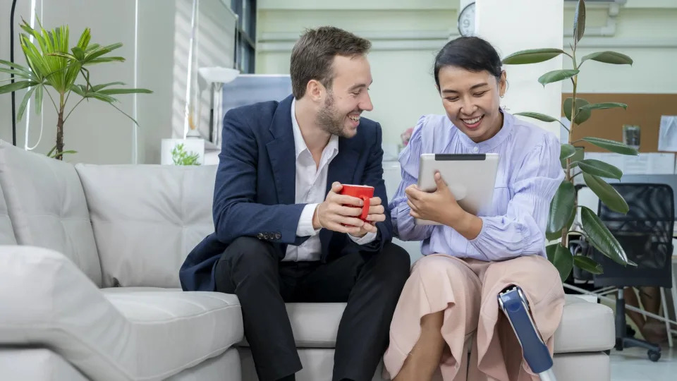 Dos personas comparten en el sillón de una sala. 