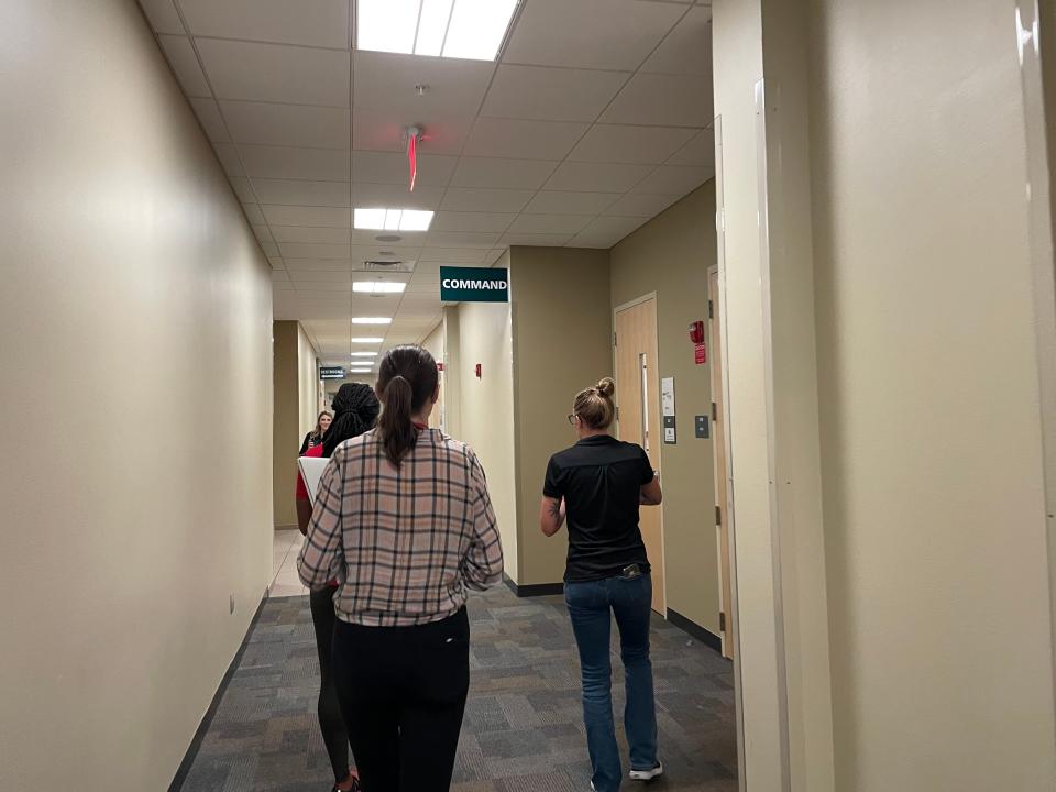 Members of the media walk with Sarasota County media relations officer Brianne Grant down a hallway in the county's Emergency Operations Center. A corps of journalists is embedding at the center during the storm.