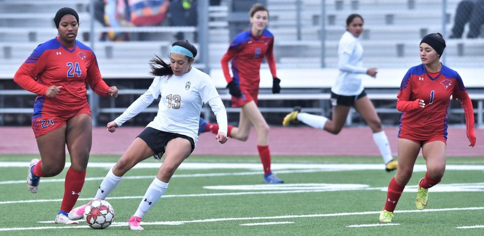 Abilene High's Laila Brown (13) dribbles the ball as Cooper's Jaya'Lyn Anderson (24) and Mackenzie Ash (1) defend in the first half.